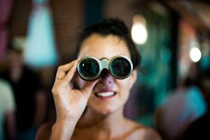 Woman looking through binoculars. Source: Chase Clark Unsplash.com