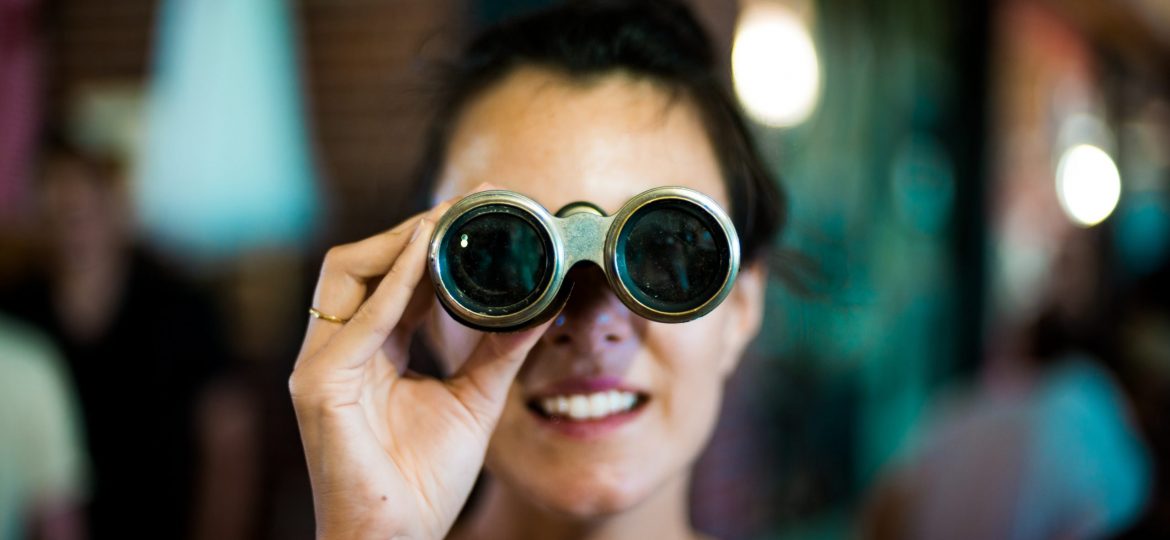 Woman looking through binoculars. Source: Chase Clark Unsplash.com